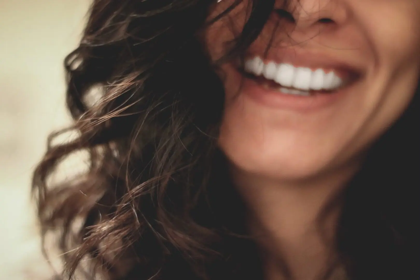 Smiling woman with wavy dark hair.