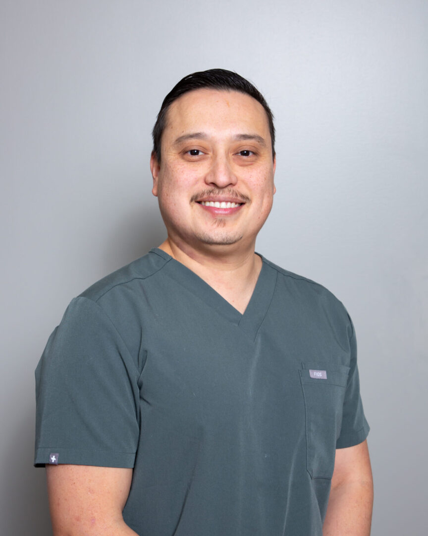 Smiling man in medical scrubs.