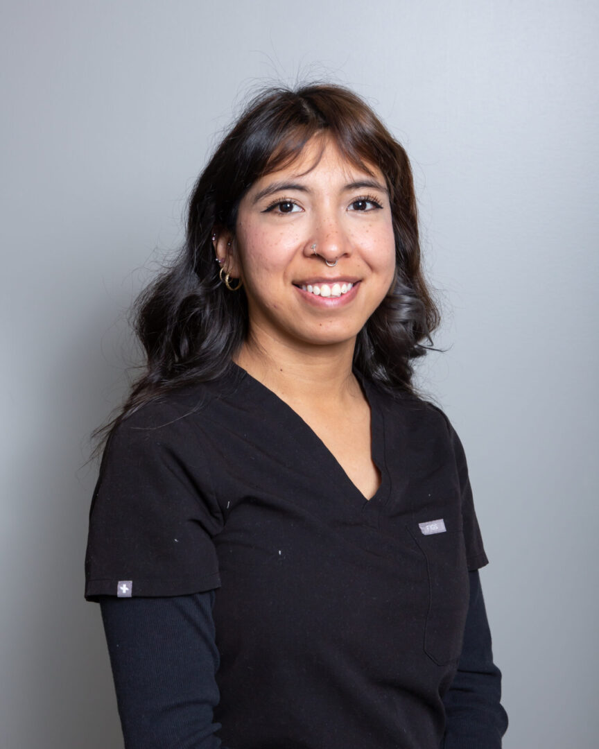 Smiling woman in black scrubs.