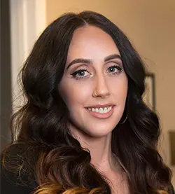 Smiling woman with long wavy hair.