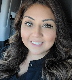 Smiling woman with long, wavy hair.