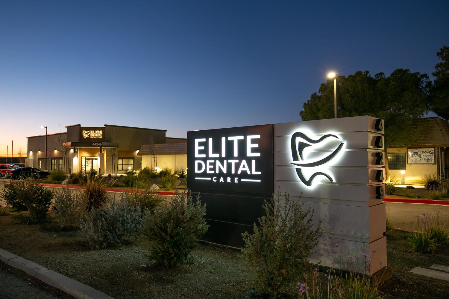 Elite Dental Care exterior signage at dusk.